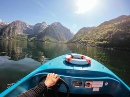 Man controls a motorboat on a mountain lake photo