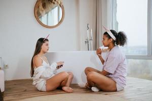 Two girls talking on the bathroom floor photo