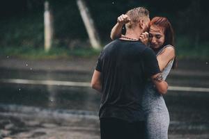 beautiful couple hugging in the rain photo