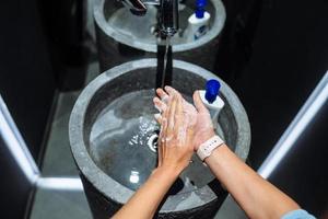 Man washing hands to protect against the coronavirus photo