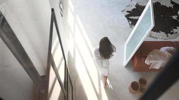 Young woman walks around home in a white robe video