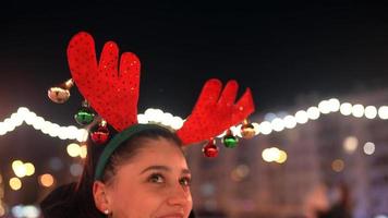 Primer plano de una mujer que lleva una fiesta festiva de asta de reno con adornos colgantes video