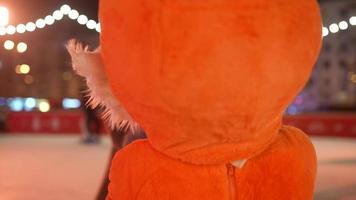 räv och rådjur maskot dansa och skridsko i utomhus- is rink på natt med Semester lampor video
