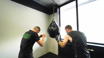 Man at boxing gym jabs at punching bag video