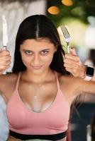 Young beautiful woman holding a knife and a fork photo