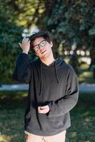 Portrait of happy young male student with glasses in casual outfit photo