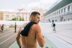 Young muscular guy with a naked torso looking back over his shoulder. photo