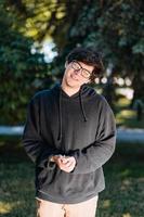 Portrait of happy young male student with glasses in casual outfit photo