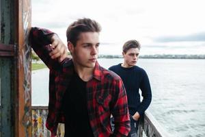 two guys stand in an abandoned building on lake photo