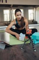 Young woman practicing yoga, is engaged with the teacher online. photo