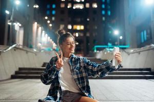 Woman talking via video call in the night city photo