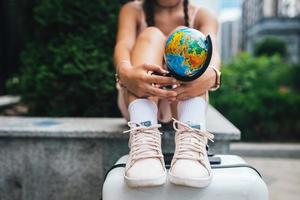 foto recortada bella joven sostiene un pequeño globo terráqueo