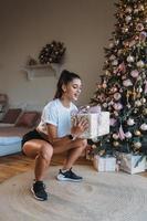 Beautiful young woman doing some squats with a gift photo