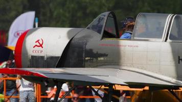 novosibirsk, fédération de russie 28 juillet 2019 - le pilote du yak 52 avion de sport du groupe de voltige barre les léopards des neiges accueille les téléspectateurs de l'airshow. meeting aérien à l'aérodrome de mochische unnm video