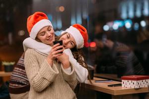 Portrait of happy cute young friends hugging each other at caffe. photo