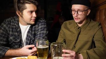 Young friends having fun together drinking beer in a pub. photo