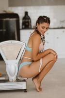 Woman in lingerie posing at the old grocery scales. Healthy eating concept photo