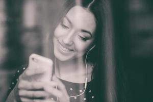 hermosa chica escuchando música en el teléfono con auriculares foto