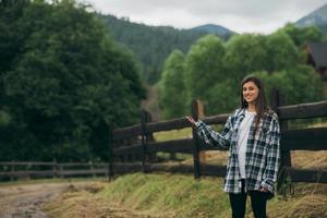 A young attractive Caucasian female sitting on a fence photo