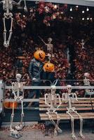 A guy and a girl with a pumpkin heads posing on the street photo