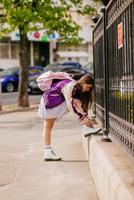 Young woman tying her shoelaces on her white boots photo