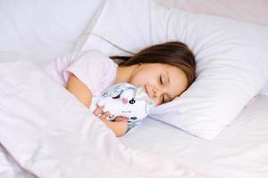 little girl with toy sleeping at home photo