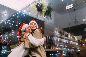 Portrait of happy cute young friends hugging each other at caffe. photo