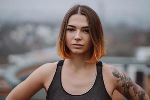 Girl poses on the roof of a building in the city center. Portrait photography photo