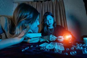 Fortune teller forecasting the future to woman with cards photo