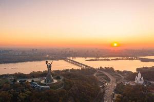 horizonte de kiev sobre la hermosa puesta de sol ardiente, ucrania. monumento patria. foto