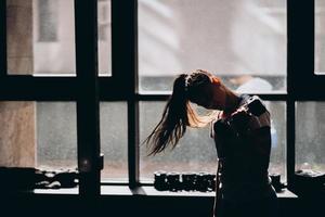 Slender athletic girl performs physical exercises with dumbbells. photo