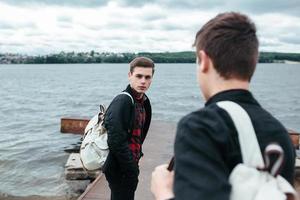 two young guys standing on a pier photo