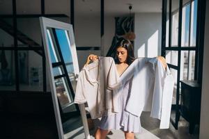 Beautiful girl trying dress in room photo