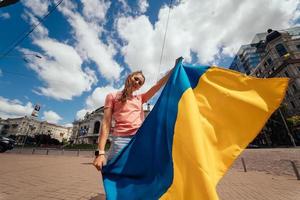 mujer joven con bandera nacional de ucrania en la calle foto