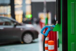 cierre el cable de alimentación del coche eléctrico. estación verde foto