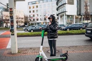 Woman in a jacket on an electric scooter in an autumn city. photo