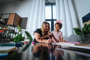 Mother and child daughter draws creatively at the table photo