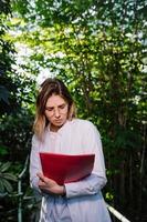 Young female agricultural engineer working in greenhouse. photo