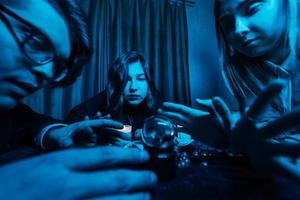 grupo de personas y mujer adivina con bola de cristal foto