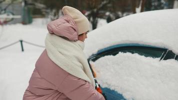 Woman removing snow from car photo