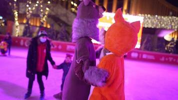 People enjoy ice skating in the street around Christmas tree in rink. photo
