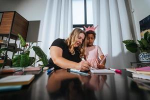 Mother and child daughter draws creatively at the table photo