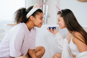 dos chicas en el baño jugando con crema facial foto