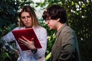 Young agricultural engineers working in greenhouse photo