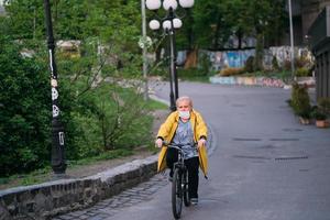 Kiev, Ukraine May 1, 2020 Old man on his bike with a surgical mask to protect himself from covid-19 in a street photo