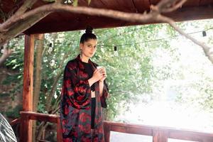 Shot of young woman drinking from tea bowl photo