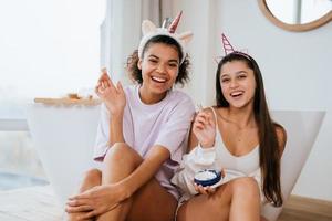 dos chicas en el baño jugando con crema facial foto