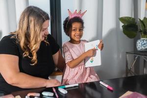 Mother and child daughter draws creatively at the table photo