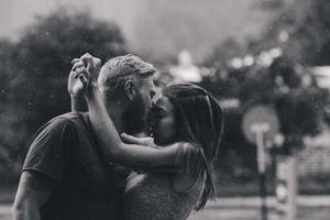 beautiful couple kissing in the rain photo