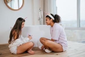 Two girls talking on the bathroom floor photo